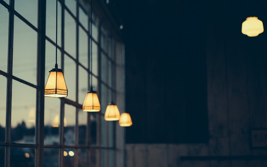 image of lights in a building next to a bank of windows.