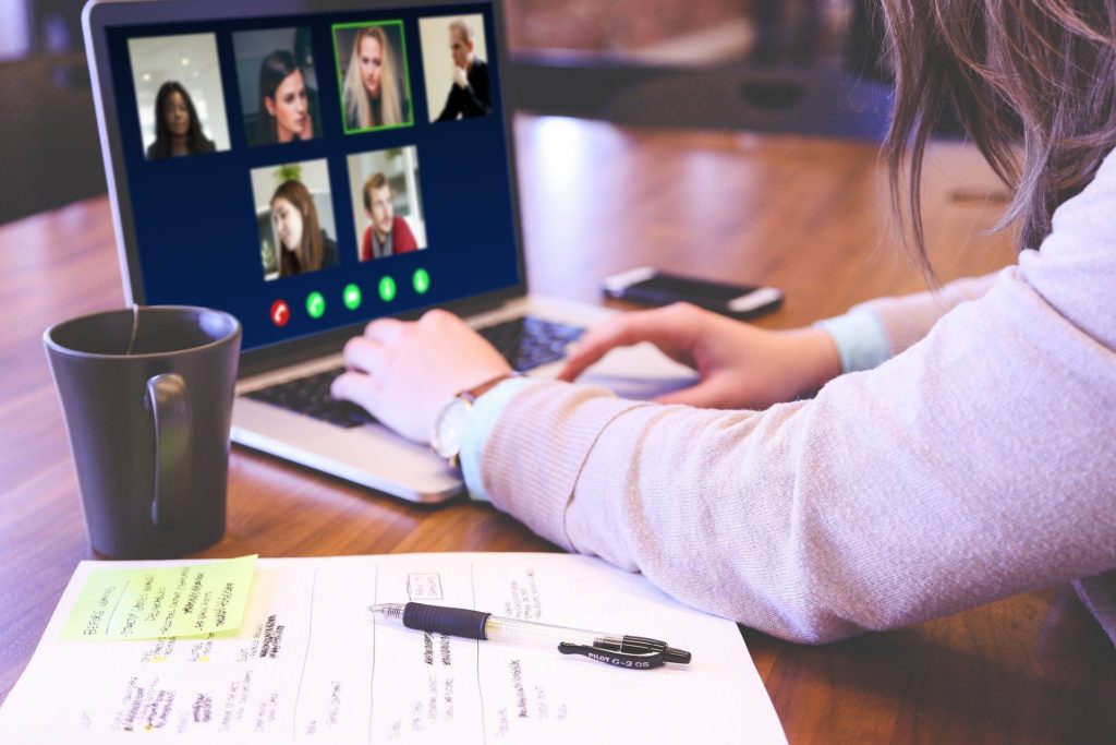 This image represents virtual events with a person viewing an online conference platform on her computer.